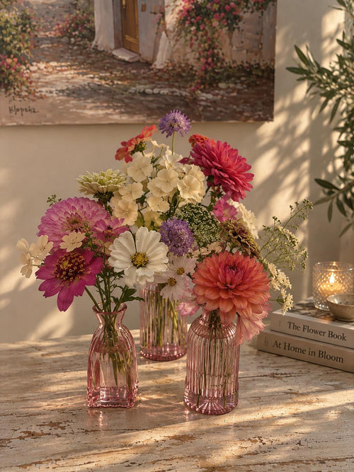 Three Botanica bud vases filled with seasonal flowers